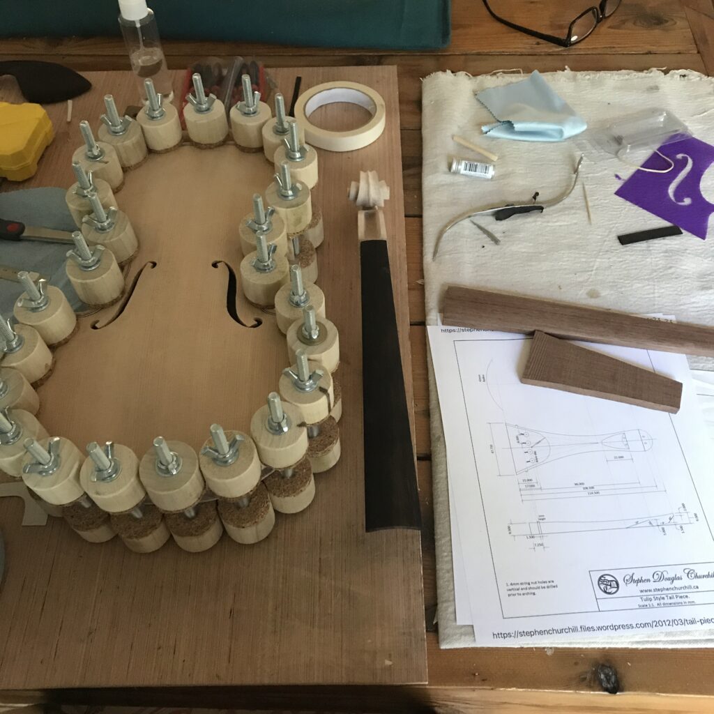 A workbench with a violin corpus glued and clamped up